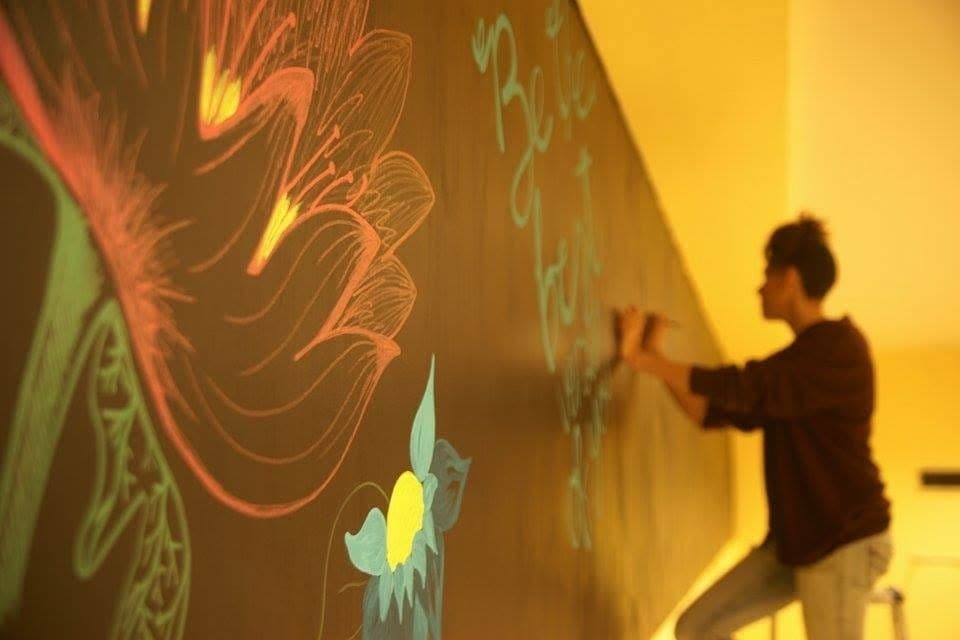 Ally decorating the chalkboard wall at Crumberry Canteens